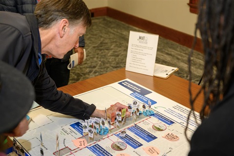 man pinning item to board